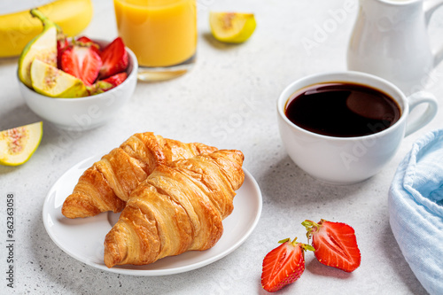 Breakfast croissants with coffee, juice and fruit.