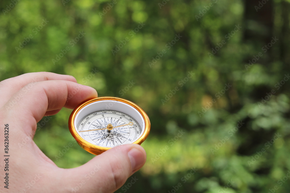 Old classic navigation compass in hand on natural background as symbol of tourism with compass, travel with compass and outdoor activities with compass Old classic navigation compass in hand on natural background as symbol of tourism with compass, travel with compass and outdoor activities with compass