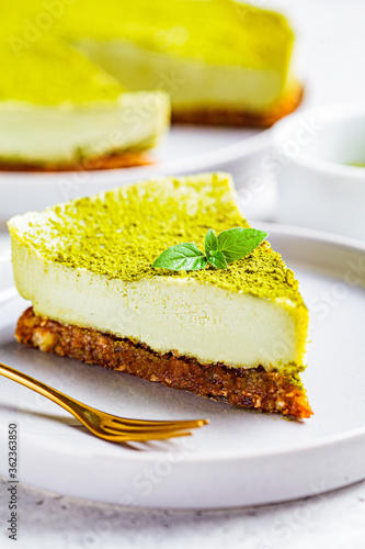 Piece of raw vegan matcha cheesecake on a gray plate.