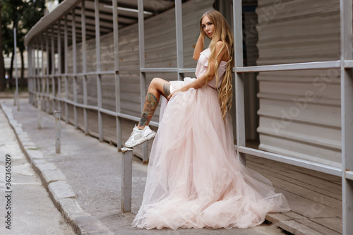 Tanned girl in wedding dress in ghetto city