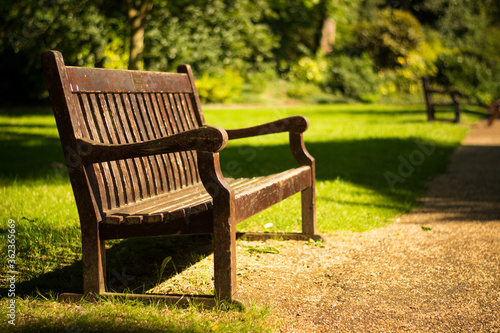 Beautiful old empty wooden bench in garden. Relax peaceful in the park © Anna