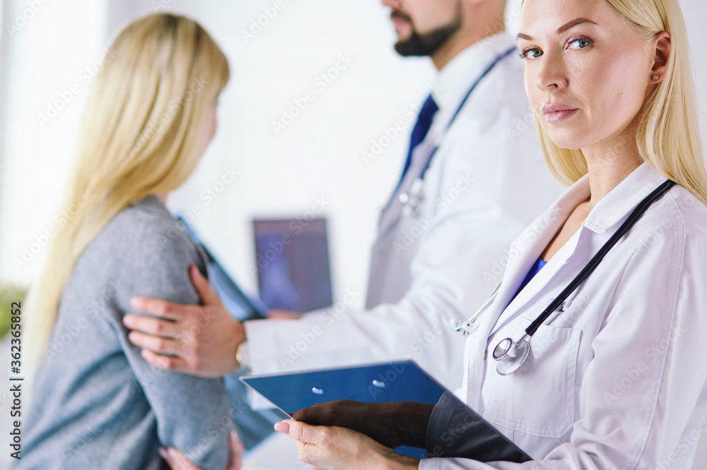 Handsome male doctor consulting a couple about infertility in his medical office Handsome male doctor consulting a couple about infertility in his medical office