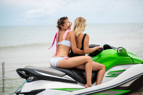 two sexy women in bikini on water scooter in sea summer style photo