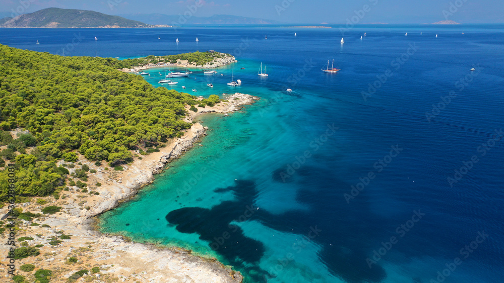 Aerial drone photo of beautiful exotic turquoise sea rocky Mediterranean island forming a blue lagoon visited by sail boats and yachts