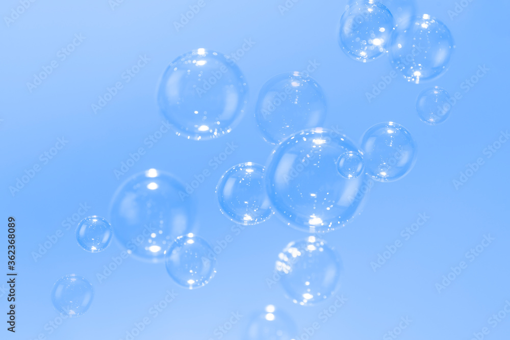 Soap bubbles float on blue background.