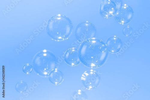 Soap bubbles float on blue background.