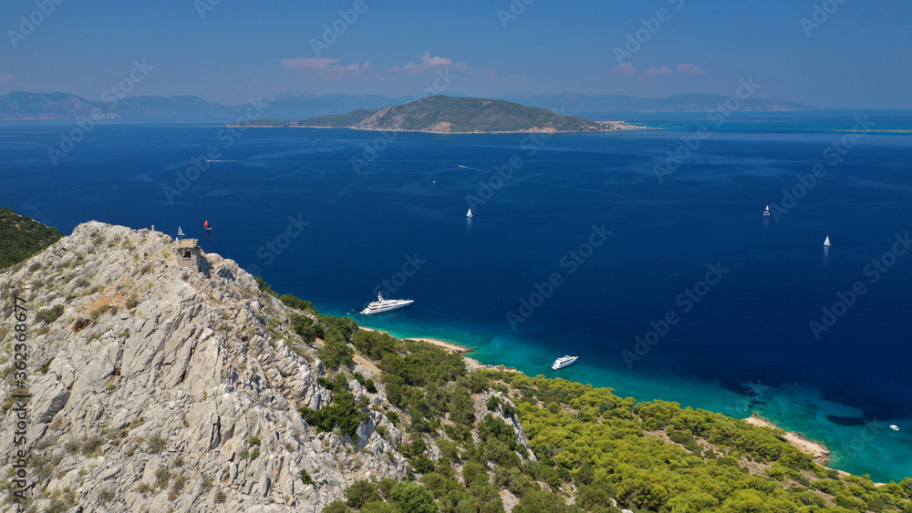 Aerial drone photo of beautiful exotic turquoise sea rocky Mediterranean island forming a blue lagoon visited by sail boats and yachts