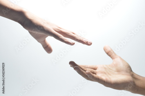 Two male hands reaching towards each other on isolated white background photo