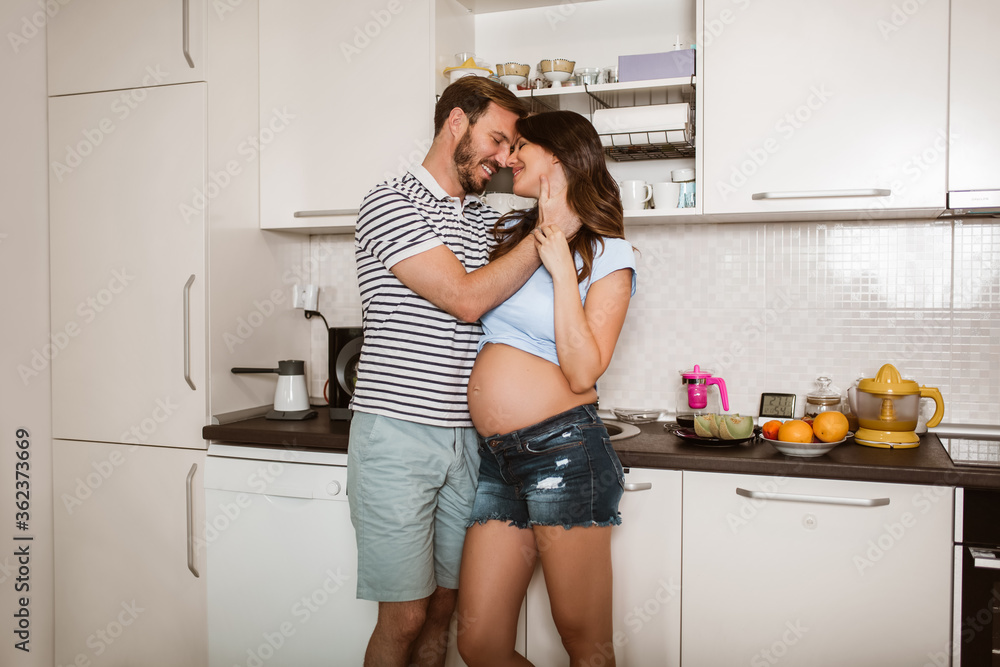 Pregnant woman with husband in the kitchen Pregnant woman with husband in the kitchen