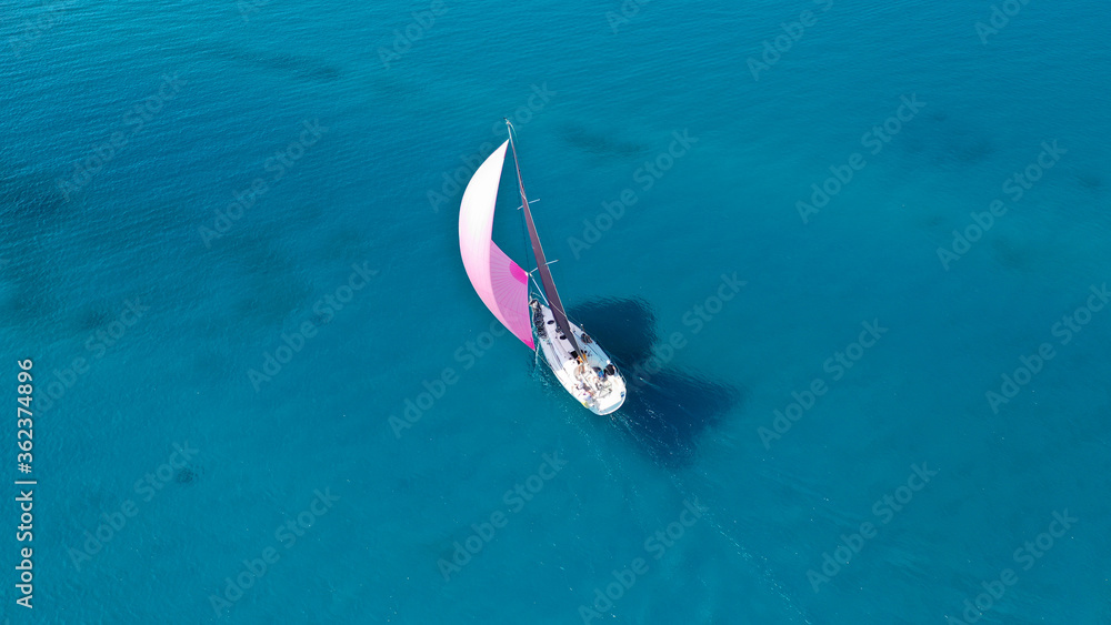 Aerial drone birds eye view of sail boat cruising the deep turquoise Aegean sea, Greece