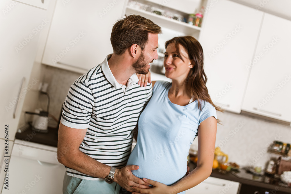 Pregnant woman with husband in the kitchen