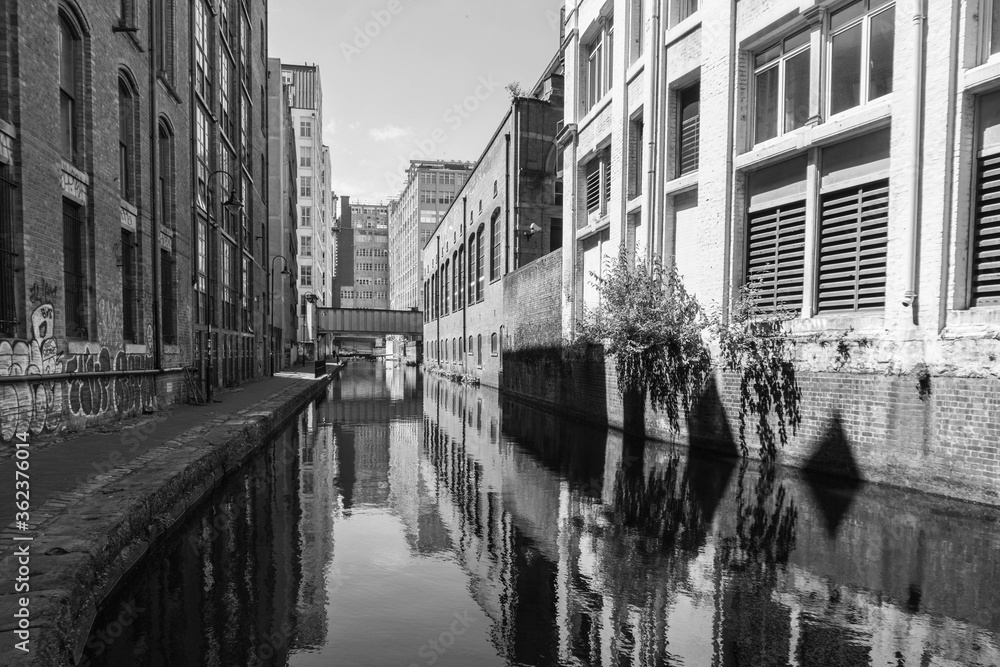 Fototapeta premium Post-industrial landscape of the Rochdale Canal as it runs through Manchester City Centre. Shot in black and white.
