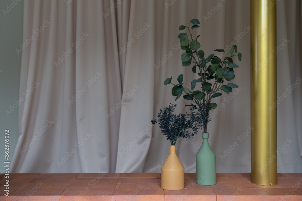 Nice artificial plant in ceramic vases setting on empty brick bench with gold column in minimal modern style apartment / residential interior concept / copy space Nice artificial plant in ceramic vases setting on empty brick bench with gold column in minimal modern style apartment / residential interior concept / copy space