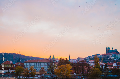 Dramatic sundown with a panoramic view of the other side of Prague in the autumn and a gradient of orange to pink colors in the cloudy sky.