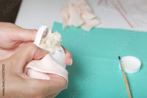 Wallpaper Mural Roses with petals made of white polymer clay. A woman sticks them on a mug. Crafts from polymer clay. Torontodigital.ca