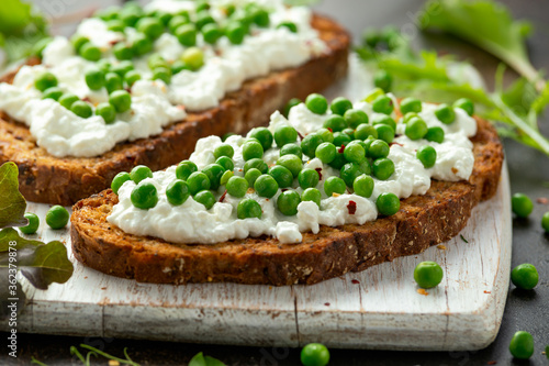 Vegetarian seeded sourdough bread open sandwich with cottage cheese and petit poit peas sprinkled with chilli flakes photo