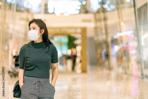 new normal after covid epidemic  young business asian female wear facial protection mask walking in center square department store mall new lifestyle after spread of corona virus covid-19 © whyframeshot