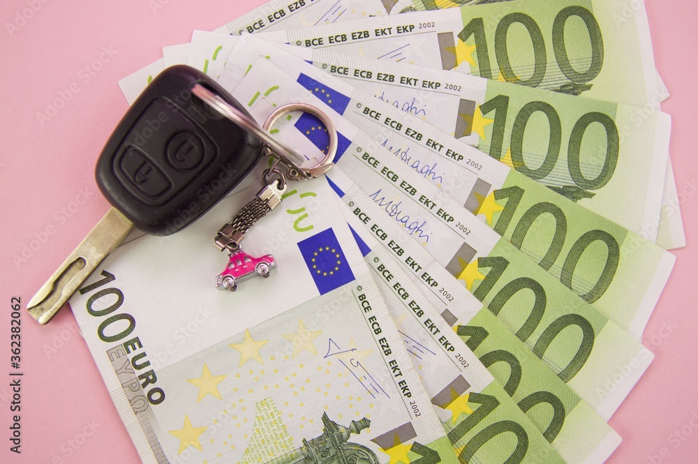 car keys lie on yellow banknotes with a nominee of 100 euros car keys lie on yellow banknotes with a nominee of 100 euros