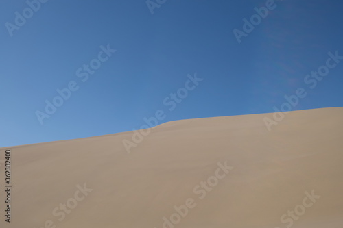 sand dune under blue sky. abstract and simplicity. At Dunhuang, Gansu province, China