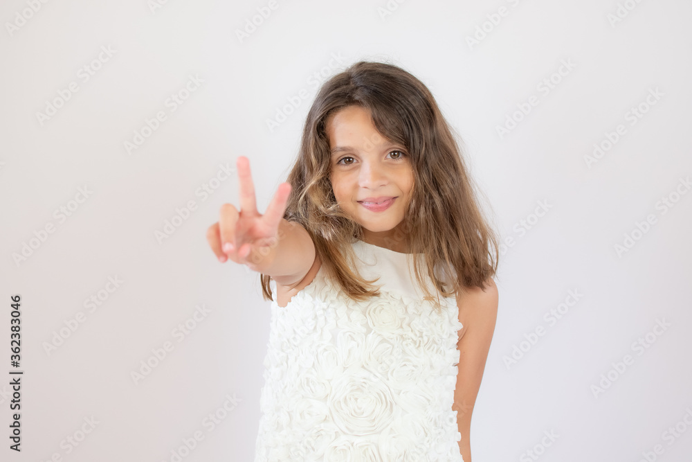 Beautiful little girl making victory gesture with her fingers Beautiful little girl making victory gesture with her fingers
