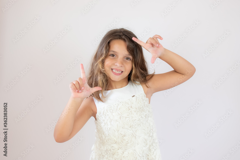 Fototapeta premium Beautiful little girl making portrait gesture