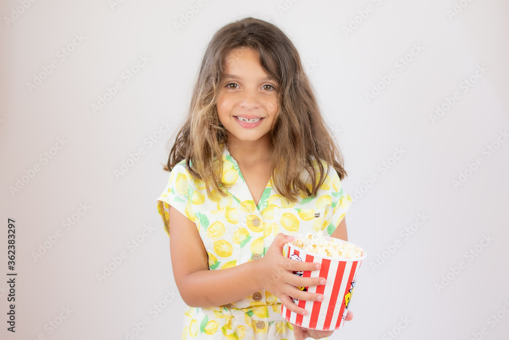Portrait of a pretty girl with yellow shirt with popcorn in hand Portrait of a pretty girl with yellow shirt with popcorn in hand