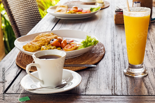 Healthy breakfast with omellete, salad, juice and coffee on wooden table