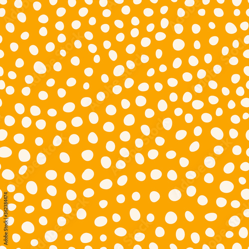 Bright spots on yellow background. Abstract seamless pattern with hand drawn uneven circles. Simple vector illustration