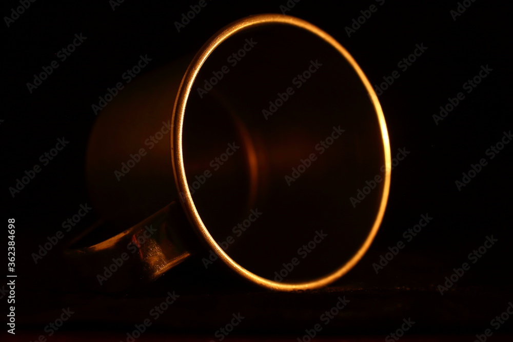 aluminum mug, circular detail with warm light and dark background. minimalist and elegant aluminum mug, circular detail with warm light and dark background. minimalist and elegant