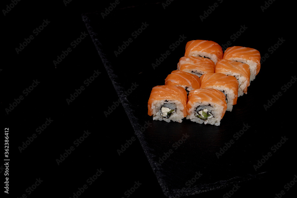 Philadelphia roll with salmon, cheese and cucumber on a black background. Sushi Philadelphia Philadelphia roll with salmon, cheese and cucumber on a black background. Sushi Philadelphia