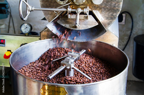 JUAYA, EL SALVADOR - MAY 03: The freshly roasted coffee beans from a large coffee roaster being poured into the cooling cylinder in Juayua, El Salvador on May 03, 2014. photo