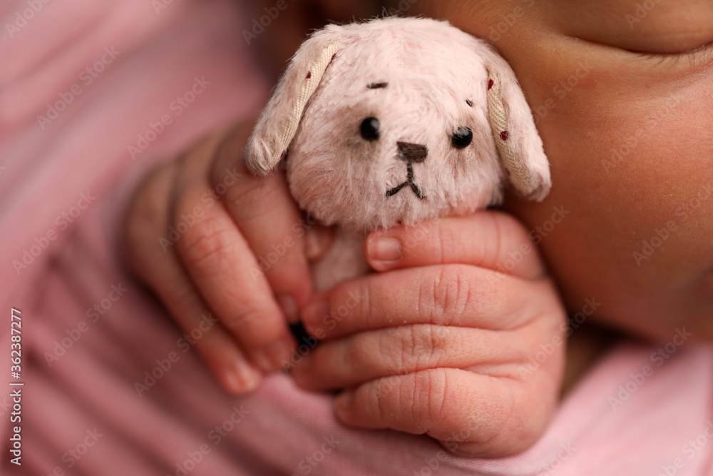 tiny toy in the hands of a newborn baby tiny toy in the hands of a newborn baby