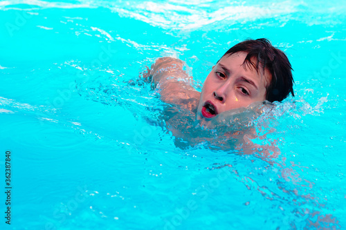 Wallpaper Mural A young athletic boy swimming in an indoor pool. Face swimmer athlete closeup in drops of water. Torontodigital.ca