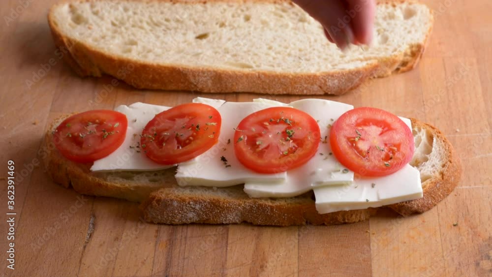 Serving a vegetarian toast from homemade bread with fresh cheese and tomato, oregano. Healthy vegetarian and vegan food Serving a vegetarian toast from homemade bread with fresh cheese and tomato, oregano. Healthy vegetarian and vegan food
