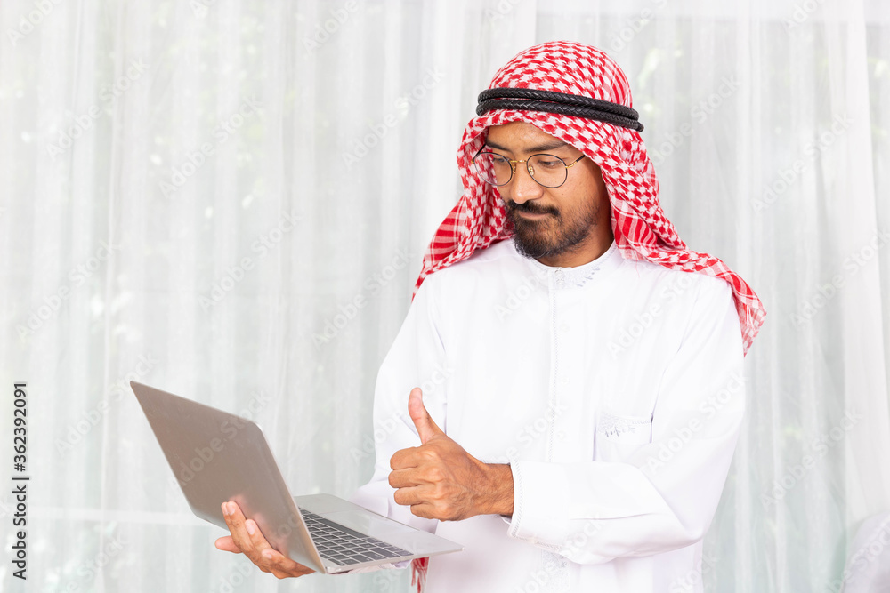 Arabian businessman smile and happy from message his computer notebook in his office Arabian businessman smile and happy from message his computer notebook in his office