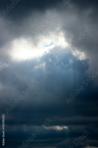 storm clouds over the city sun shines through the clouds