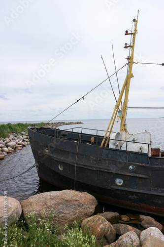 old abandoned fishing boat stuck in the stones