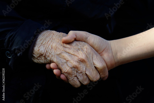 Old and young holding hands. Family love concept. Healthcare background.
