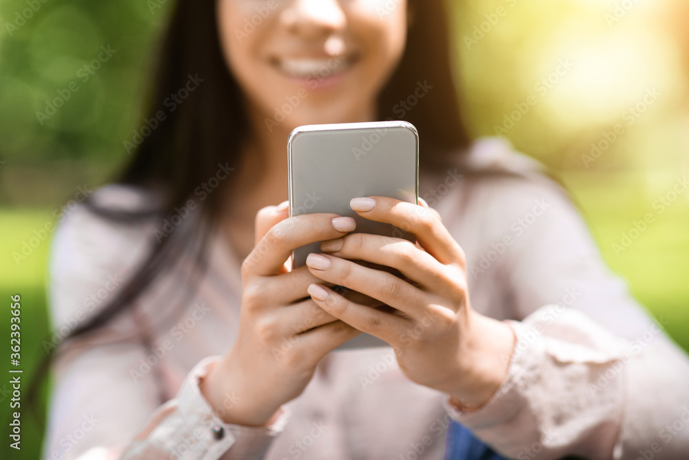 Closeup Image Of Modern Smartphone In Hands Of Smiling Girl Standing Outdoors Closeup Image Of Modern Smartphone In Hands Of Smiling Girl Standing Outdoors