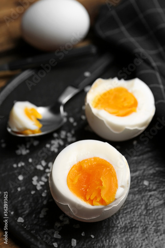 Tasty boiled chicken eggs on slate plate, closeup
