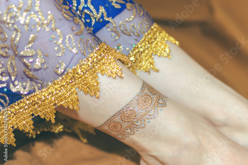 Indian woman cosplay. Young beautiful woman in blue indian sari dress closeup on the multicolored brown background. Body parts