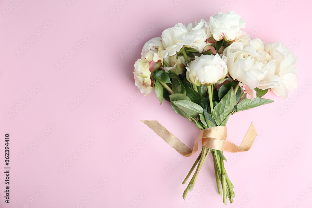 Bouquet of beautiful peonies with ribbon on pink background, flat lay. Space for text