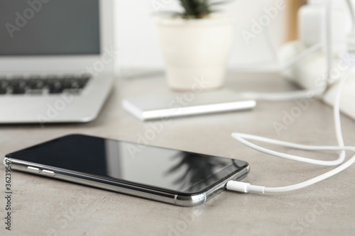 Wallpaper Mural Smartphone charging with cable on light stone table Torontodigital.ca