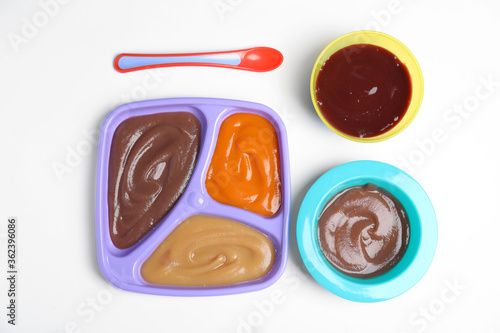 Flat lay composition with healthy baby food and spoon on white background