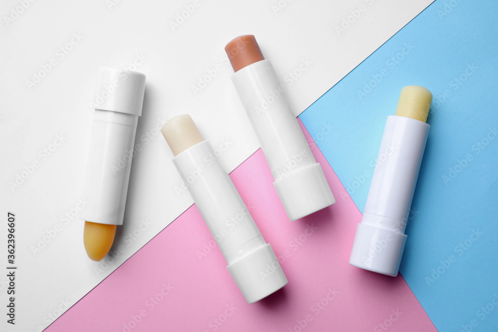 Hygienic lipsticks on color background, flat lay Hygienic lipsticks on color background, flat lay