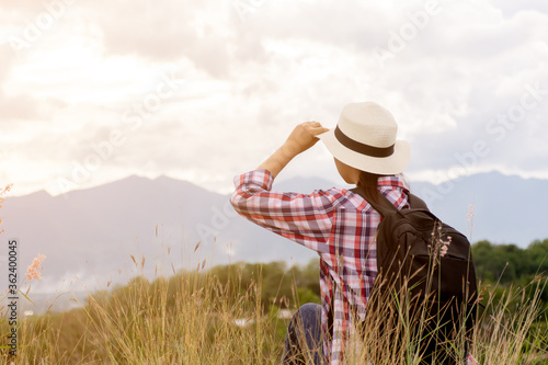 girl traveler with backpacker looking to beautiful mountain