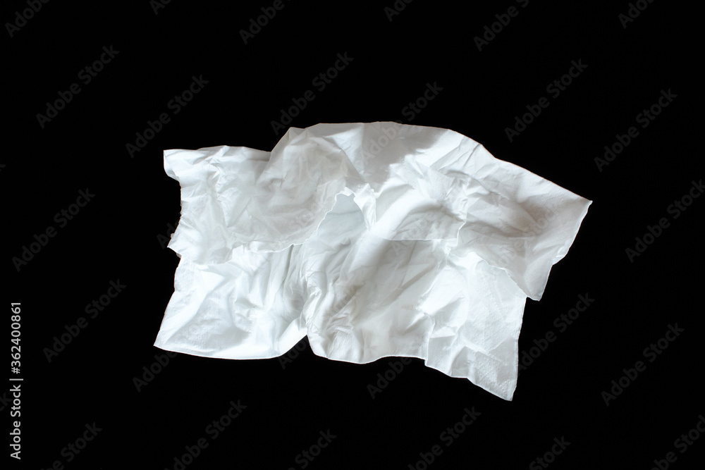 Used paper napkin isolated on black background. Crumpled tissue