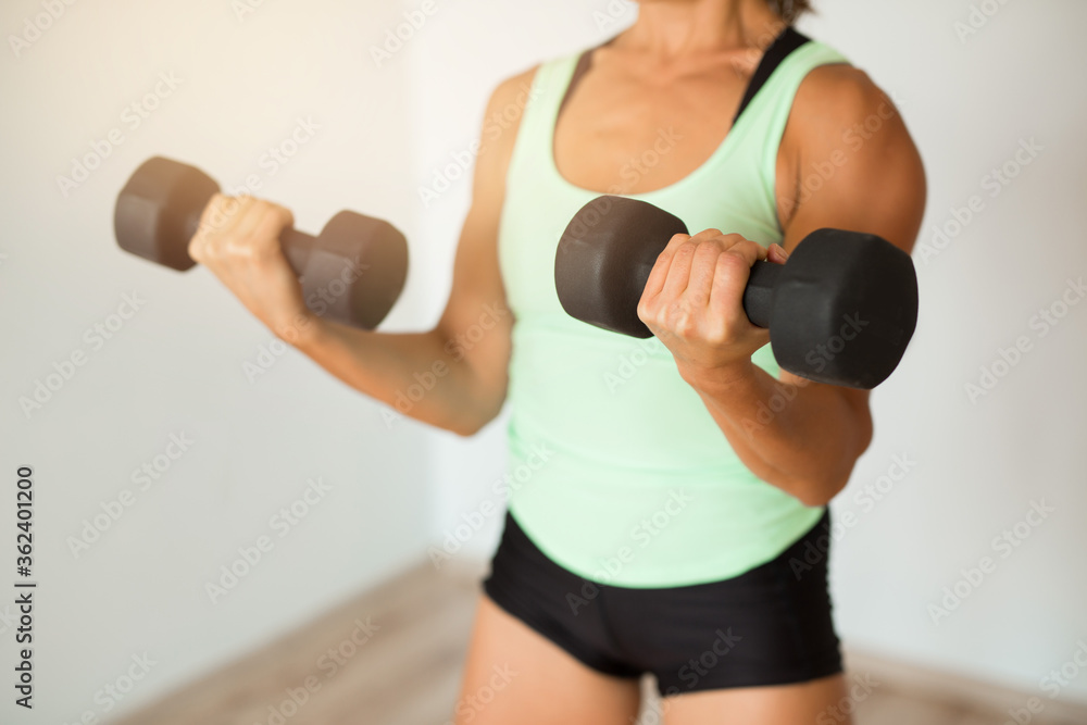 beautiful young woman doing home workout with dumbbells beautiful young woman doing home workout with dumbbells