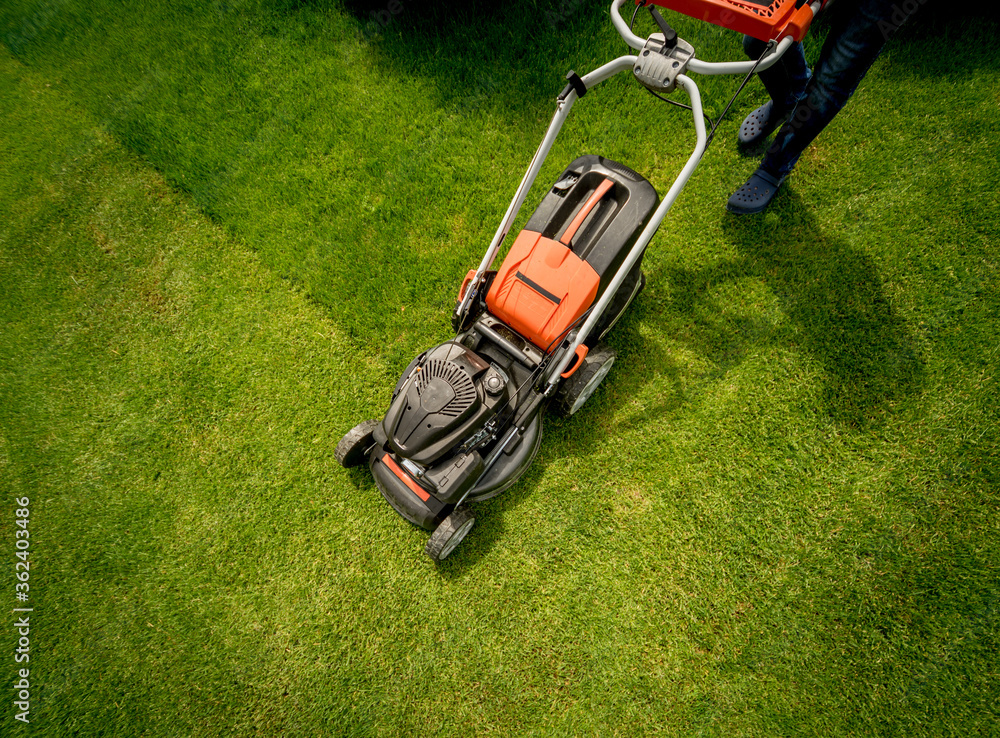 Gardener mowing the lawn. Landscape design. Green grass background Gardener mowing the lawn. Landscape design. Green grass background