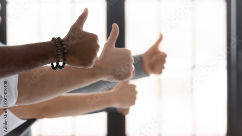 Hands of diverse people show thumbs up gesture close up. Satisfied multiracial clients express positive feedback of company services. Great offer. Successful teamwork results, racial equality concept